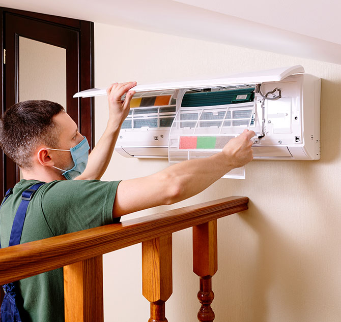 Affordable AC service technician inspecting air conditioner